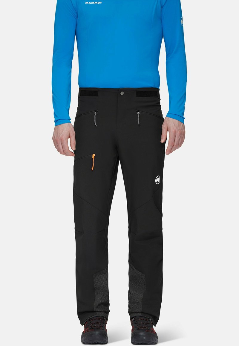 Czarne spodnie narciarskie z elastycznym paskiem, zamykanymi na zamek kieszeniami i pomarańczowym sznurkiem do regulacji. Posiadają wzmocnione dolne nogawki z teksturowanymi akcentami.