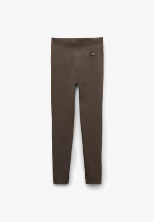 Dunkelbraune Leggings mit hoher Taille und einem kleinen "clz"-Etikett auf der oberen rechten Seite, auf weißem Hintergrund dargestellt.