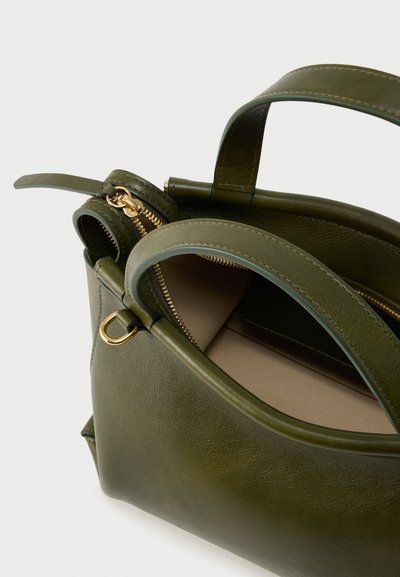 Τσάντα χειρός από δέρμα ελιάς με χρυστό φερμουάρ, δύο επάνω λαβές και εσωτερική τσέπη. Διαθέτει ομαλή υφή και δομημένο σχήμα.