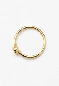 Anello d'oro con un design circolare e liscio, caratterizzato da un accento quadrato piatto su un lato. La superficie presenta una finitura lucida.