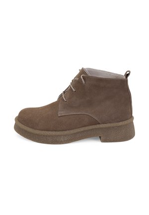 Bottines en daim marron avec un bout arrondi, un design minimaliste, des coutures légères contrastées et une semelle en caoutchouc texturée.