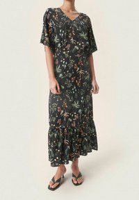 Maxi dress nera con stampa floreale, maniche a volants corte, scollatura a V, orlo a strati con volant e motivi vegetali colorati in arancione, verde e blu.