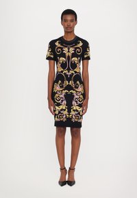 Rochie neagră, ajustată, cu mâneci scurte, decorată cu broderie florală complexă în nuanțe de roz și galben. Material neted, design până la genunchi și siluetă elegantă.