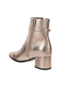 Metalen ros�égouden enkellaars met een puntige neus en chunky hak, voorzien van een zijrits en tabaccent voor eenvoudig aan- en uittrekken.