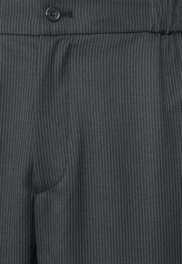 Black pinstripe trousers with a smooth texture, featuring a single button closure and side pockets. Tailored design, formal appearance.