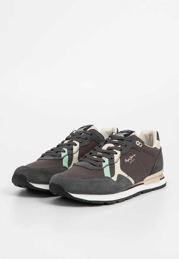 Zapatillas marrones con ante gris, acentos en verde menta y crema. Presentan una suela texturizada y cierre de cordones. Logotipo característico exhibido.