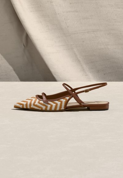 Φλατ σανδάλι με μυτερή μύτη, υφαντό σχέδιο σε χρώμα ταμπά και λευκό ζιγκ ζαγκ και λεπτά καφέ δερμάτινα λουράκια στον αστράγαλο και στο πάνω μέρος του ποδιού με μικρή αγκράφα.