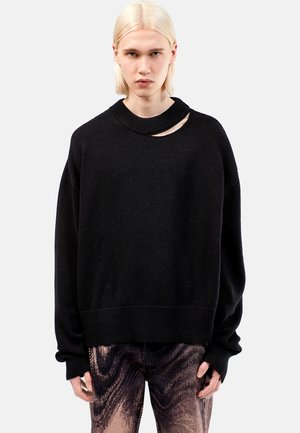 Black oversized sweater with a ribbed crew neck and a distinctive cutout detail. Soft texture with dropped shoulders and wide cuffs.