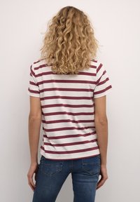 Gestreept t-shirt met bordeauxrode en crèmekleurige horizontale strepen, korte mouwen en een relaxte pasvorm. Gemaakt van zachte stof met een gladde textuur.