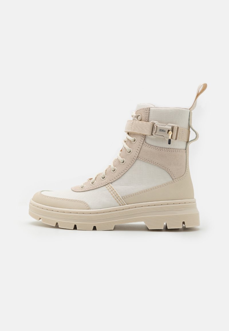 Stivale alto beige con suola spessa, chiusura con lacci frontale, cinturino con velcro e fibbia, e linguetta in tessuto sul tallone, mostrato in profilo laterale.