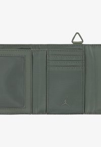 Billetera de tela gris con múltiples ranuras para tarjetas, un bolsillo transparente para identificación y un logo de Jumpman. Cuenta con una superficie texturizada y detalles cosidos.