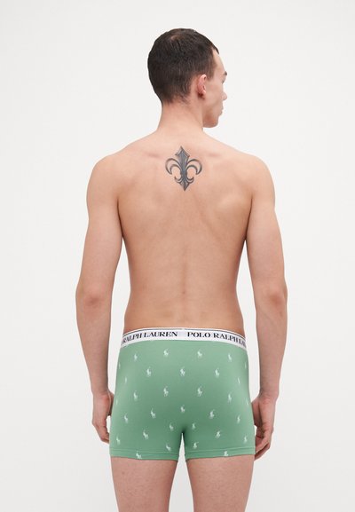 Zelene pamučne bokserice s bijelim elastičnim pojasom na kojem je natpis "POLO RALPH LAUREN." Dizajn uključuje male bijele logotipe konjića raspršene po cijeloj površini.