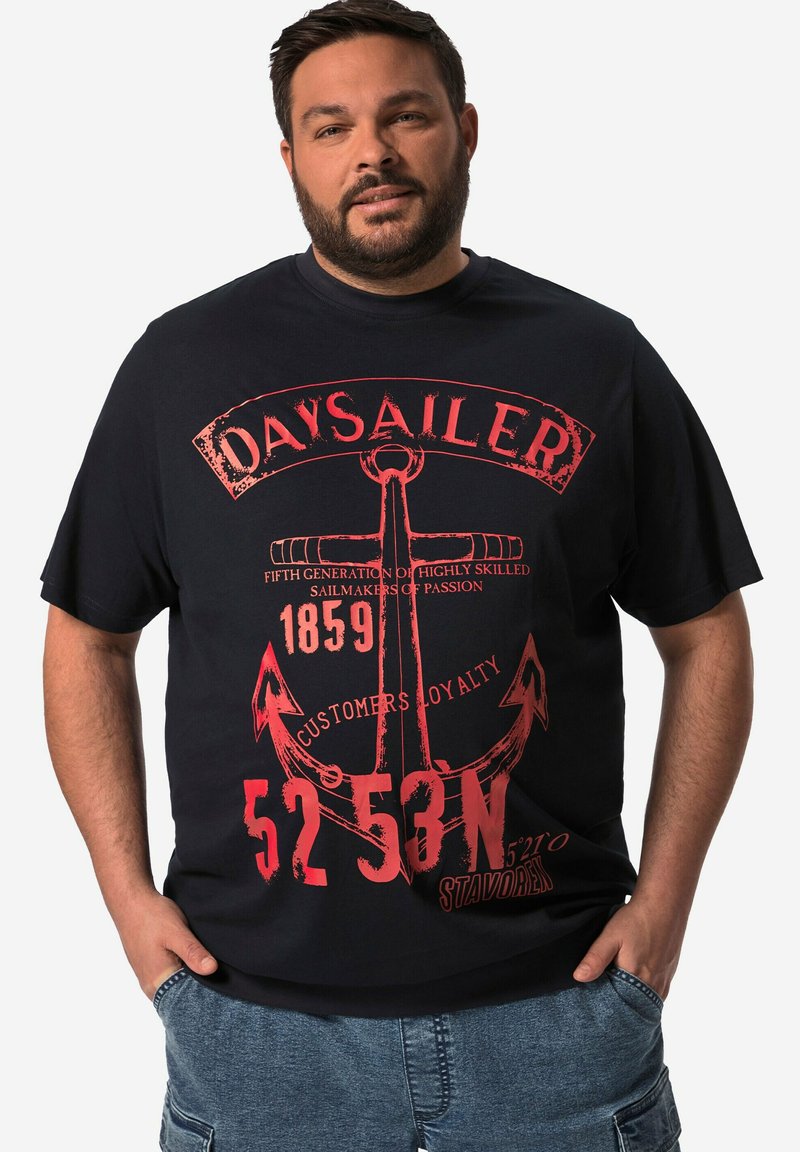 Svart bomullströja med stort röd grafiskt tryck av ett ankare och text, korta ärmar och en avslappnad passform. Marint tema.