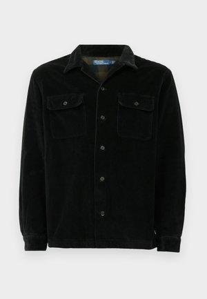 Black corduroy shirt with a classic collar, two chest pockets, button closure, and a ribbed texture. Long sleeves with button cuffs.