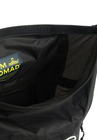 Black fabric bag with a smooth exterior and reinforced seams. Interior features a grid pattern and a label with yellow text.