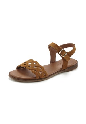 Brown suede flat sandal with woven front strap and adjustable ankle strap featuring a silver buckle. Soft footbed and flat sole.