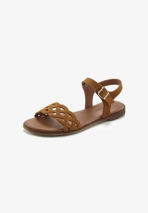 Brown suede flat sandal with woven front strap and adjustable ankle strap featuring a silver buckle. Soft footbed and flat sole.