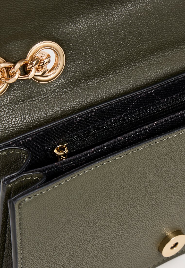 Sac en cuir vert olive avec une chaîne dorée, intérieur en tissu noir et compartiment zippé, montrant des détails de texture et de couture.