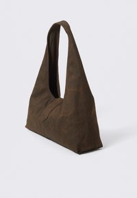 Bolso de hombro de tela marrón con forma triangular, que cuenta con un asa ancha y curvada, y una textura suave con un sutil detalle de patrón.