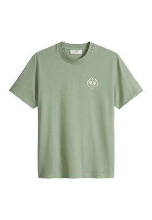 T-shirt vert sauge à manches courtes avec col rond, petit logo blanc « Mood Sports » et illustration d'une raquette de tennis sur le côté gauche de la poitrine.