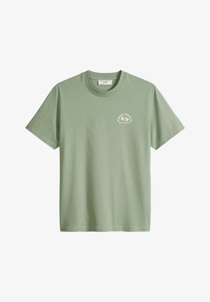 T-shirt vert sauge à manches courtes avec col rond, petit logo blanc « Mood Sports » et illustration d'une raquette de tennis sur le côté gauche de la poitrine.