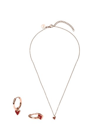 Roségold Halskette und Creolen mit kleinen roten herzförmigen Anhängern auf weißem Hintergrund.