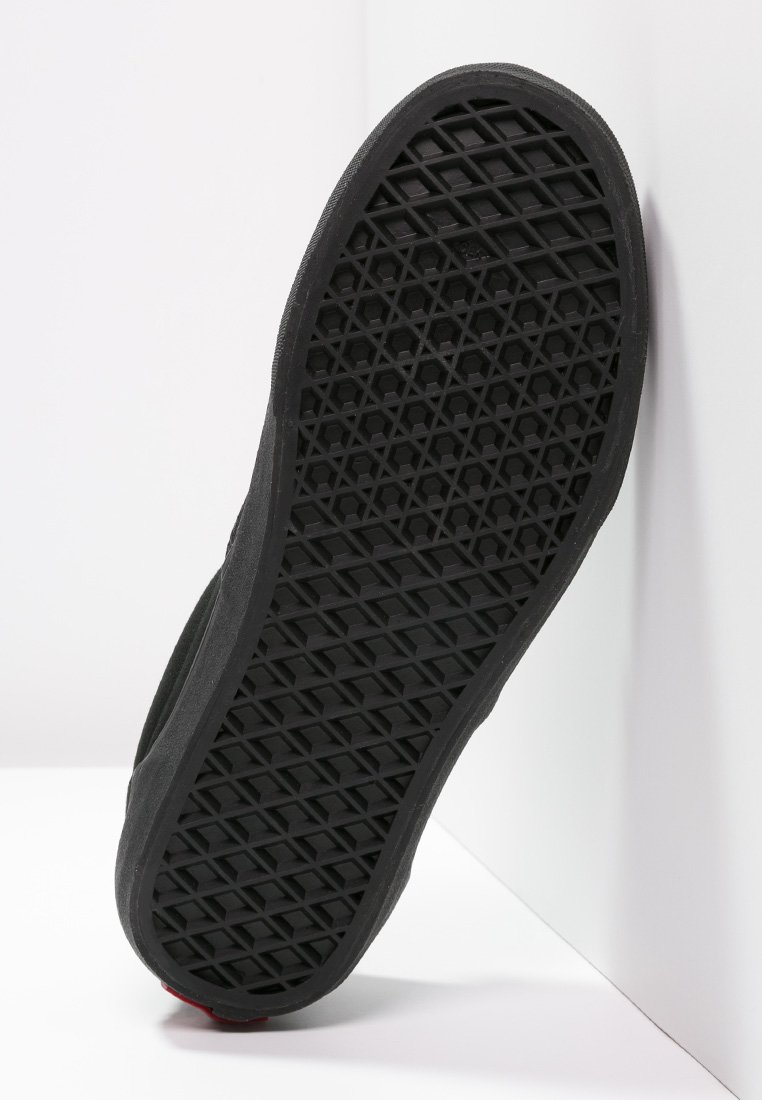 Semelle de chaussure en caoutchouc noir avec un motif hexagonal texturé, présentant un design plat et un léger profil latéral sur fond blanc.