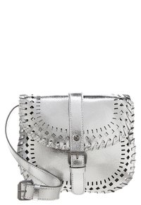 Mała srebrna torebka na ramię z metalu, z klapką i zapięciem na klamrę, ozdobiona perforowanym wzorem dekoracyjnym oraz regulowanym paskiem.