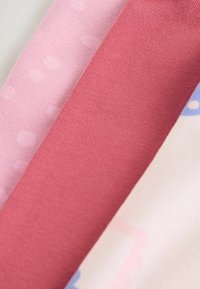 Drie stofstalen in zachte kleuren: lichtroze met stippen, effen donkerder roze, en een gestreepte lichtroze met blauwe accenten.