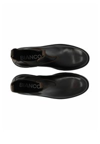 Botas de cuero negras hasta el tobillo con paneles laterales elásticos, punteras redondeadas y costuras visibles. El interior etiquetado presenta el nombre de la marca "BIANCO."