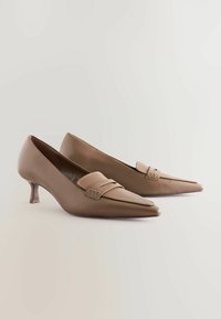 Braune Leder-Heelschuhe mit spitz zulaufendem Design und niedrigem Absatz. Besitzt einen dekorativen Riemen mit einem minimalistischen Schnallendetail.