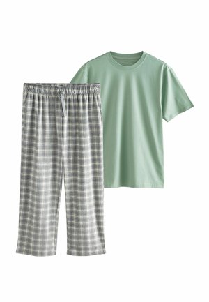 Lys grøn bomulds T-shirt med korte ærmer parret med grå og hvide ternede flannelbukser med elastisk talje.