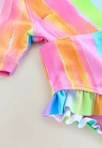 Colorful swim garment featuring horizontal stripes in pink, orange, green, and blue. Ruffled edges at the bottom add texture and detail.