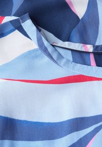 Tessuto di colore blu e rosa con un motivo, dalla superficie liscia, con scollatura rotonda e strisce sovrapposte di diverse larghezze.