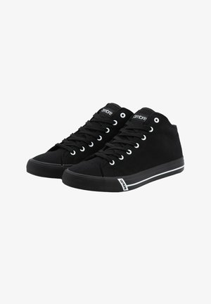 Zapatillas altas negras de lona con suela de goma, que cuentan con ojales blancos, franjas blancas en contraste en la suela y un logo.