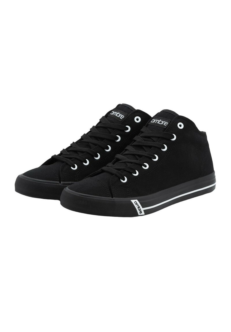 Zapatillas altas negras de lona con suela de goma, que cuentan con ojales blancos, franjas blancas en contraste en la suela y un logo.