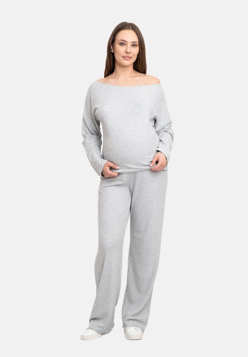 Set di abbigliamento loungewear in cotone grigio chiaro, composto da un top a maniche lunghe e spalle scoperte e pantaloni morbidi, caratterizzato da un design rilassato.