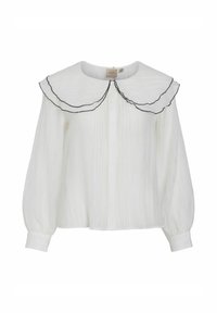 Blusa blanca de tejido texturizado con un gran cuello rizado bordeado de negro y manga larga abullonada con puños abotonados.