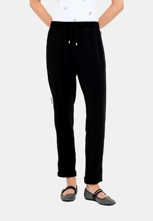 Pantaloni sportivi neri con vita elastica e coulisse, dotati di tasche laterali e vestibilità rilassata. Tessuto liscio con una consistenza morbida.