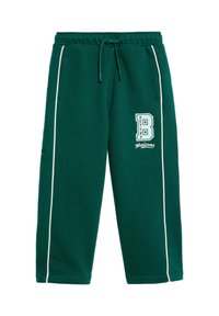 Pantalones de chándal verdes hechos de una tela suave, con rayas laterales blancas, cinturilla con cordón y un logotipo decorativo "B" en el lado izquierdo.