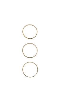 Trzy złocone metalowe pierścienie o różnych rozmiarach, z teksturowaną powierzchnią i subtelnymi różnicami w grubości.