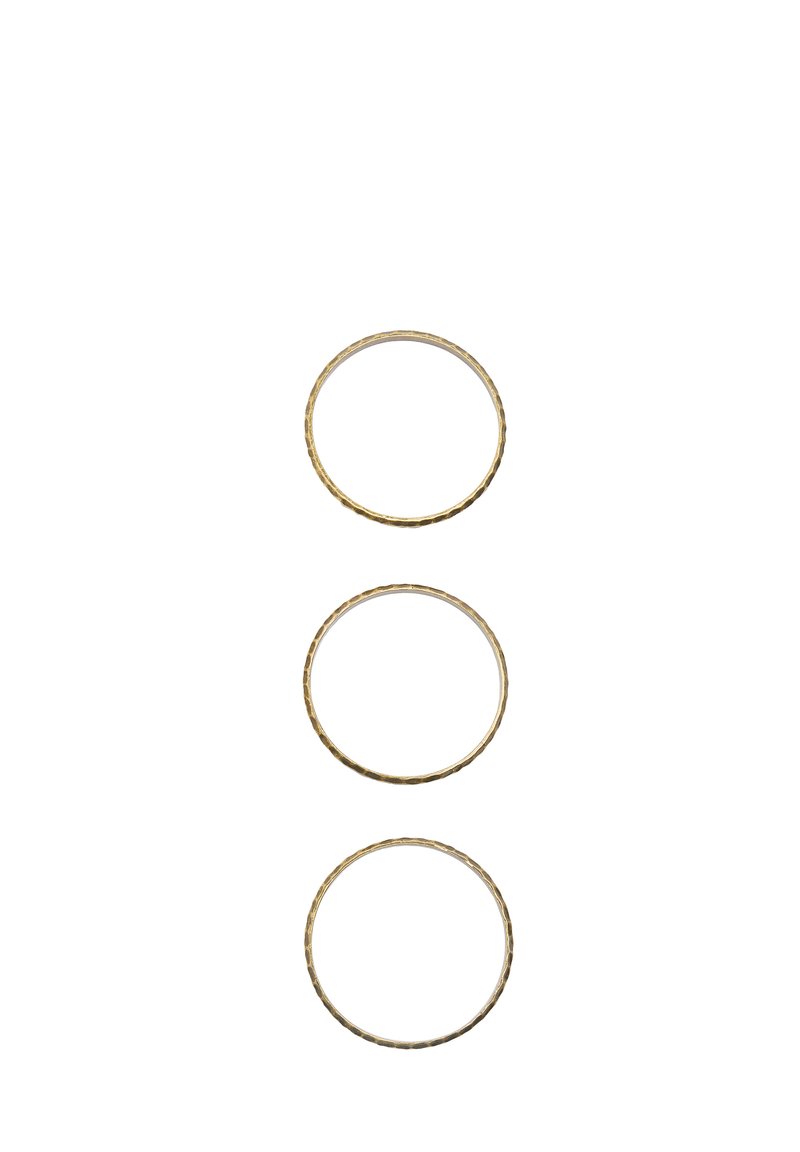 Trzy złocone metalowe pierścienie o różnych rozmiarach, z teksturowaną powierzchnią i subtelnymi różnicami w grubości.