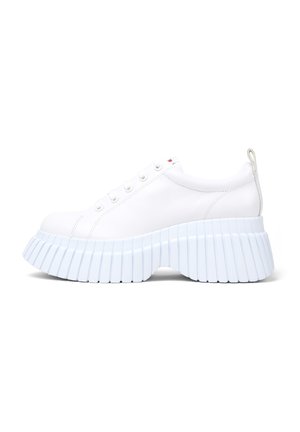 White sneaker with a rounded toe and thick, ribbed light blue platform sole; features eyelets and a small tab on the heel.