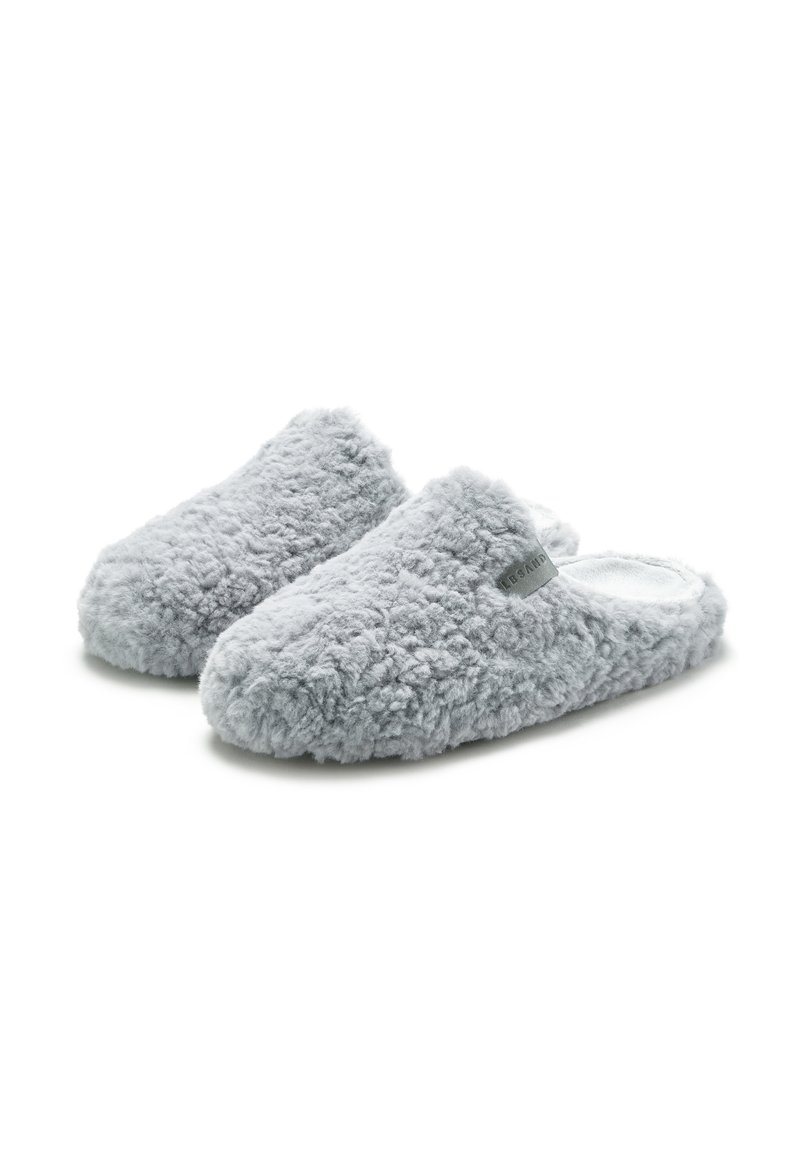 Pelēki, pūkaini čības ar teksturētu audumu, atvērtu aizmuguri un nelielu logotipa birku sānos; mīksts, luksusa materiāls ērtībai.