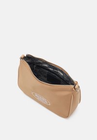 Tan syntetisk väska med dragkedjestängning, med ett svart mönstrat inre. Inkluderar en präglad logotyp på framsidan och en silverfärgad detalj.