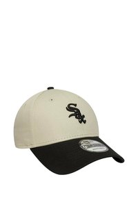 Cappellino beige e nero con visiera curva, dotato di un logo "Sox" ricamato in nero sul davanti e un'etichetta New Era sul lato.
