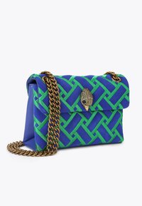 Borsa intrecciata blu e verde con motivo trapuntato, dotata di una tracolla in catena dorata e di un dettaglio decorativo a forma di pavone sulla patta.
