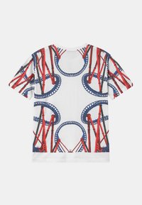 Hvid bomulds t-shirt med et grafisk design af røde rutsjebanebaner og blå sløjfer, med rund hals og korte ærmer.