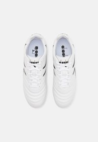 Valge nahast Diadora tennisekingade paar musta logo ja paeltega, vaadatuna pealt lihtsalt valgel taustal.