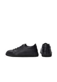 Zwarte leren sneakers met een gladde textuur, ronde neus, vetersluiting en een dikke zwarte rubberen zool. Geen zichtbare patronen of accenten.